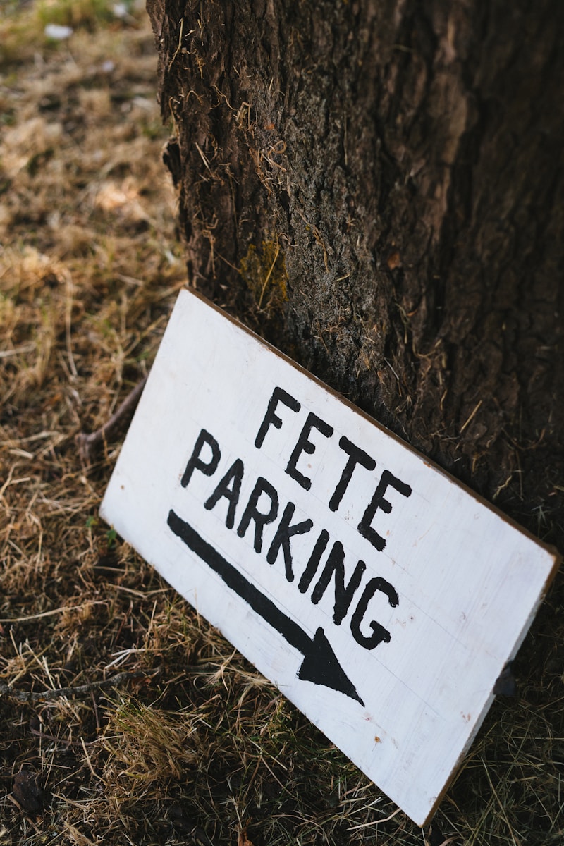 A white sign that is on the side of a tree
